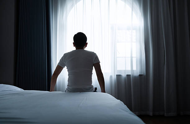 Sitting on the edge of the bed at dawn